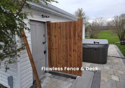 Wooden privacy fence beside door shielding hot tub